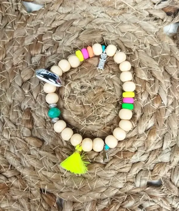 Bracelet à perles bois avec breloques et pompon jaune fluo.