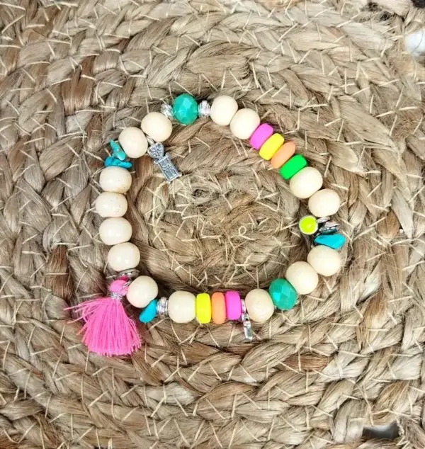 Bracelet à perles bois, breloques et pompon rose fluo.