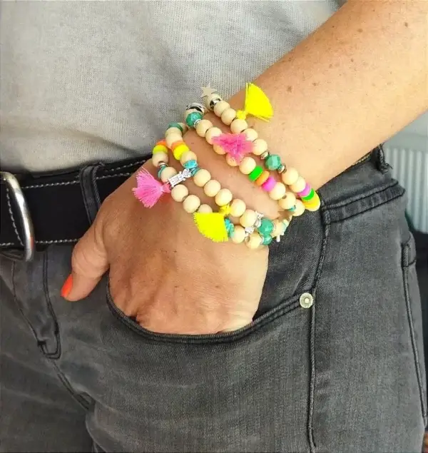 Bracelet à perles bois, breloques et pompon rose fluo.