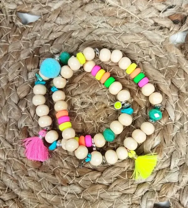 Duo de bracelets à perles en bois avec breloques et pompons rose et jaune fluo.