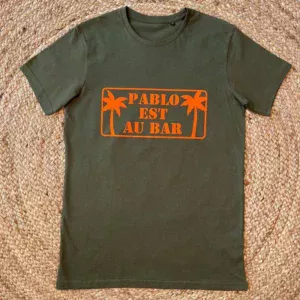 Tee-shirt kaki pour homme avec slogan "Pablo est au bar" en orange fluo.