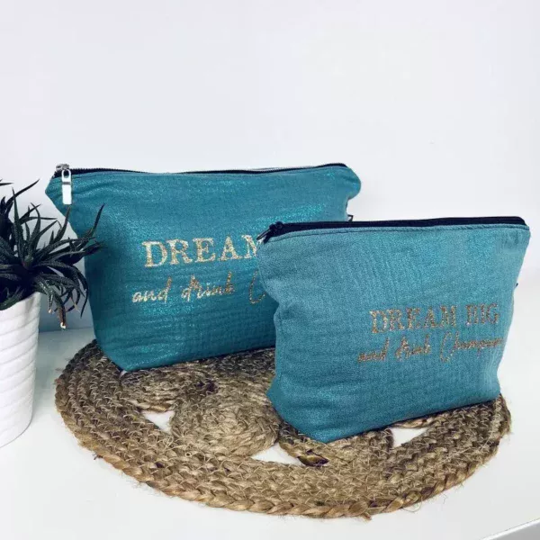 Grande pochette Midnight en gaze de coton bleu irisé avec slogan "Dream big and drink Champagne" en or pailleté