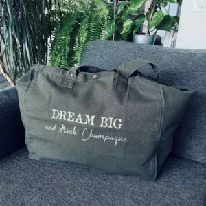 Sac fourre-tout kaki avec slogan "Dream Big and drink Champagne" en doré pailleté.