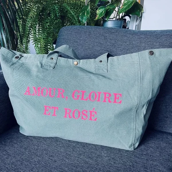 Sac fourre-tout vert sauge avec slogan "Amour, Gloire et rosé" en rose fluo.