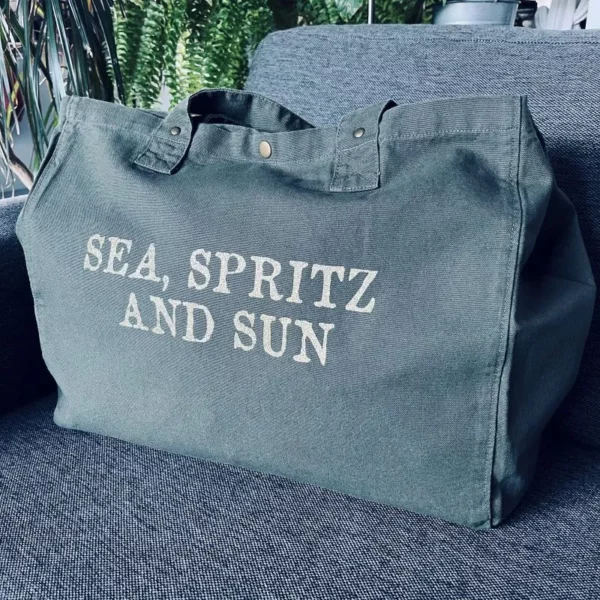 Sac fourre-tout kaki avec slogan "Sea, Spritz and Sun" en or pailleté.