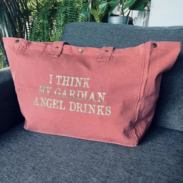 Sac fourre-tout vieux rose avec slogan "I think my gardian angel drinks" en doré pailleté.