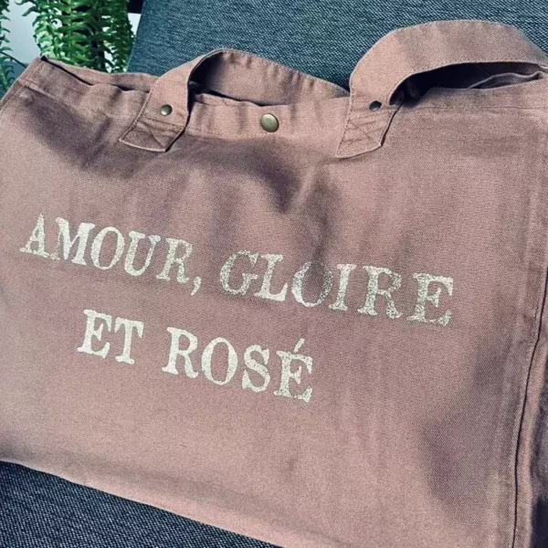 Sac fourre-tout santal avec slogan "Amour, Gloire et rosé" en or pailleté.