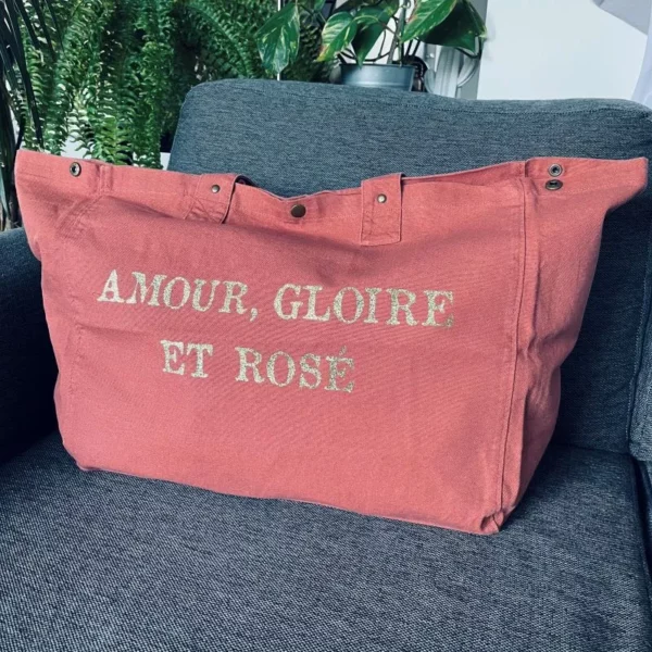 Sac fourre-tout vieux rose avec slogan "Amour, Gloire et rosé" en or pailleté.