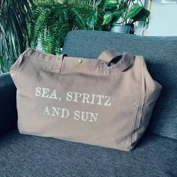 Sac fourre-tout santal avec slogan "Sea, Spritz and Sun" en or pailleté.