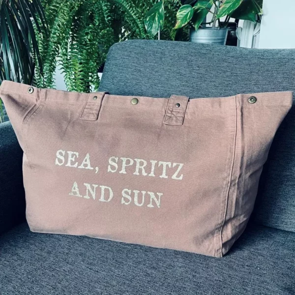 Sac fourre-tout santal avec slogan "Sea, Spritz and Sun" en or pailleté.