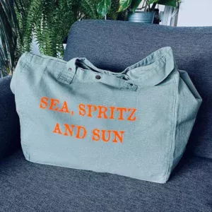 Sac fourre-tout vert sauge avec slogan "Sea, Spritz and Sun" en orange fluo.