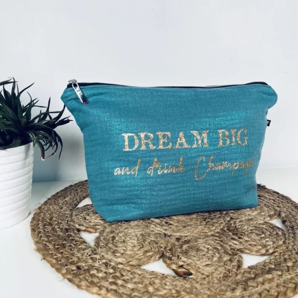 Trousse de toilette en gaze de coton bleu avec slogan "Dream big and drink Chamapgne" en or pailleté.