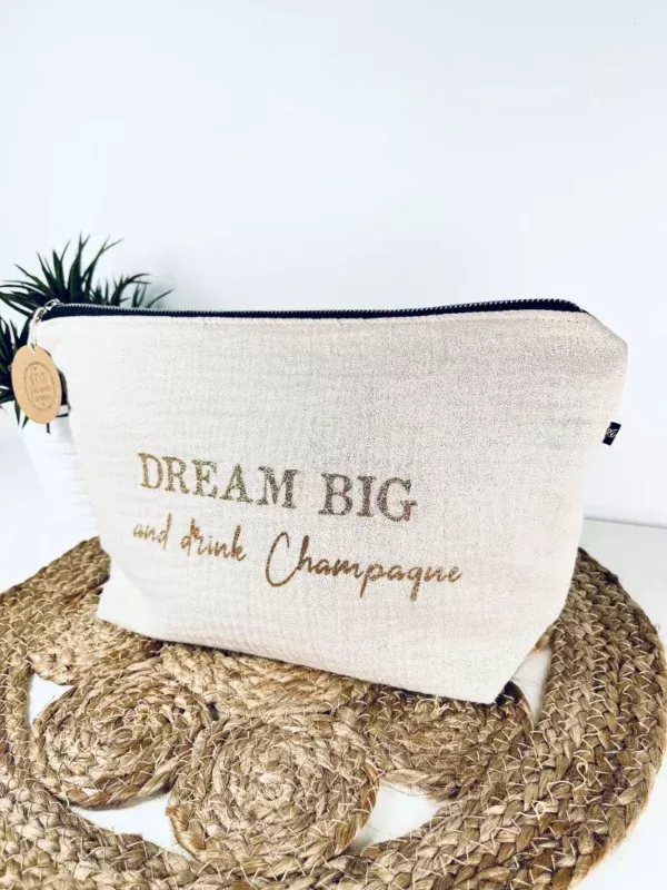 Trousse de toilette en gaze de coton blanc avec slogan "Dream big and drink Chamapgne" en or pailleté.