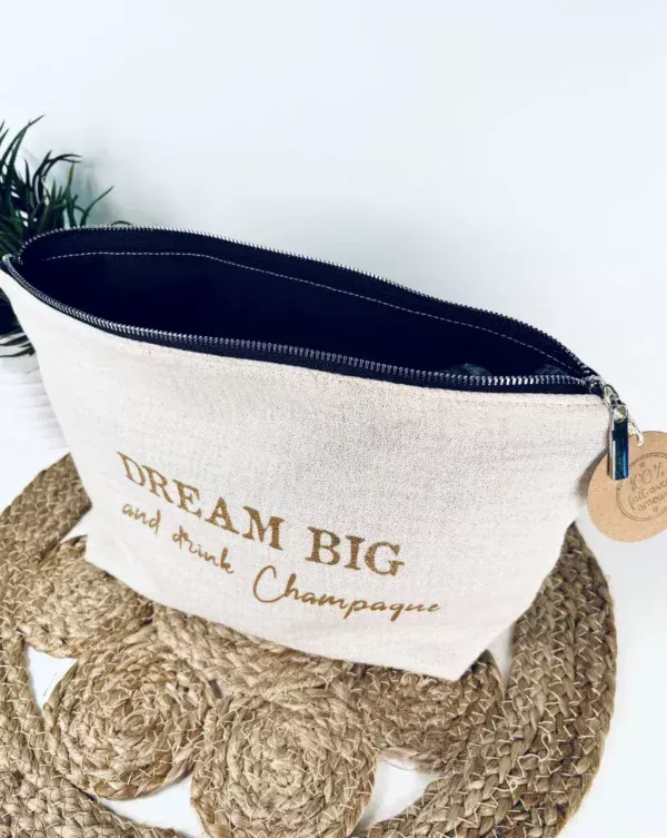 Trousse de toilette en gaze de coton blanc avec slogan "Dream big and drink Chamapgne" en or pailleté.