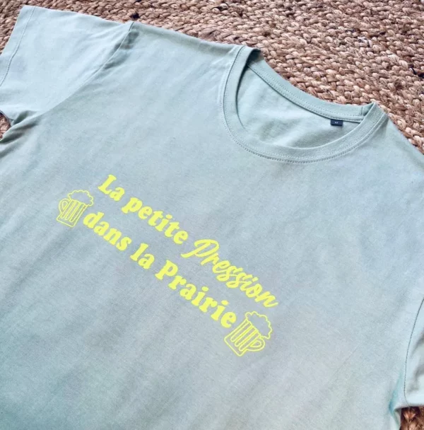Tee-shirt homme vert sauge avec flocage "La petite pression dans la prairie" en jaune fluo.