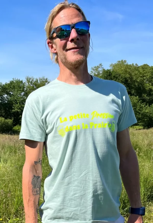 Tee-shirt homme vert sauge avec flocage "La petite pression dans la prairie" en jaune fluo.