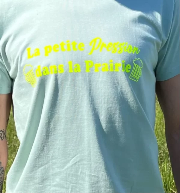 Tee-shirt homme vert sauge avec flocage "La petite pression dans la prairie" en jaune fluo.