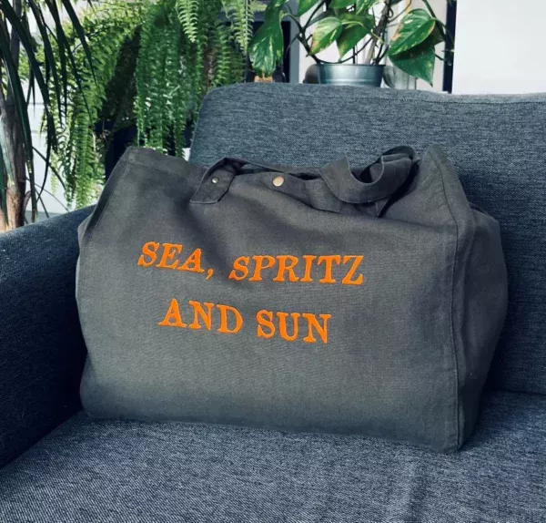 Sac fourre-tout kaki avec flocage "Sea, Spritz and Sun" en orange fluo.